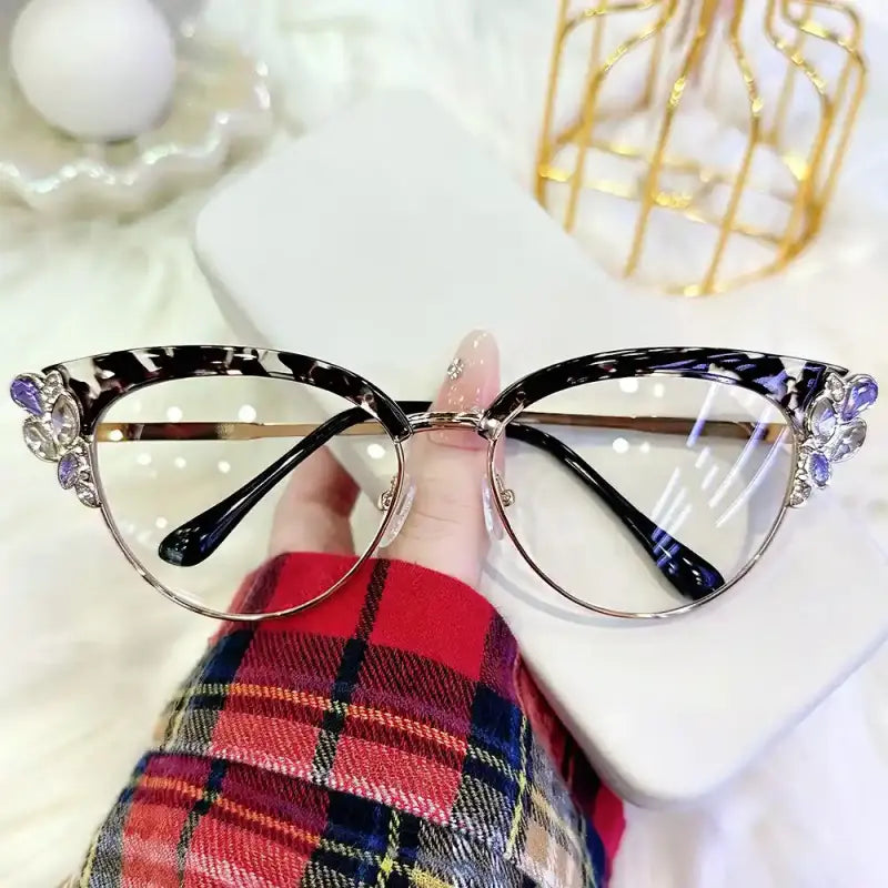 Elenate your style with our vintage glam cat eye browline glasses! Featuring a chic black and white marble tortoiseshell upper frame adorned with sparkling purple and clear crystal jewels along the winged corners. Perfect for soft glam, office siren vibes & statement everyday chic. Shop now!