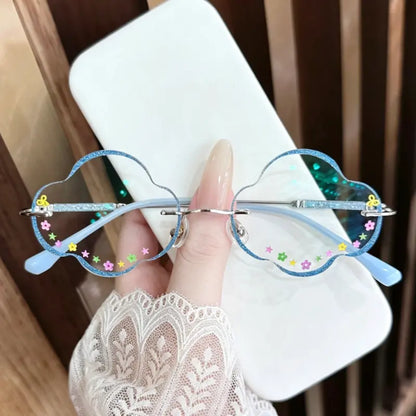 Step into a dream with our whimsical cloud-shaped glasses! Featuring a glittering blue wavy rim and playful flower & star decals, these unique rimless frames are the perfect Y2K or Fairycore accessory for your next photoshoot or festival look. Shop the trend!