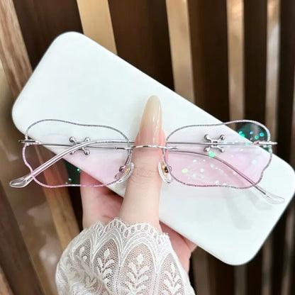 Upgrade your look with these whimsical wavy rimless glasses! Featuring a sparkling glitter edge, unique cross-hardware detailing, and dreamy pink lenses, these glasses are the perfect Y2K or Fairycore accessory for your next photoshoot or everyday outfit. Shop this statement piece now!