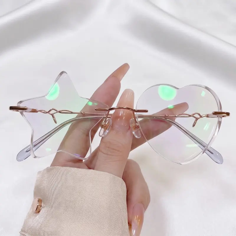 Make a fun statement with our mismatched star and heart rimless clear glasses! Featuring a whimsical asymmetric star & heart shape, crystal clear cut-out lenses, and elegant rose gold metal temples. Perfect for Y2K, rave festivals & photo props. Shop now!