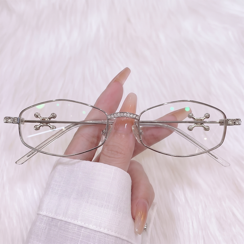 Upgrade your edgy look with our Y2K cyber silver narrow oval glasses! Featuring a dazzling rhinestone-encrusted bridge, silver cross stud lens accents, and clear lenses. Perfect for chrome aesthetics & gothic grunge styles. Shop now!