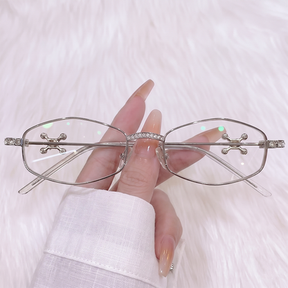 Upgrade your edgy look with our Y2K cyber silver narrow oval glasses! Featuring a dazzling rhinestone-encrusted bridge, silver cross stud lens accents, and clear lenses. Perfect for chrome aesthetics & gothic grunge styles. Shop now!