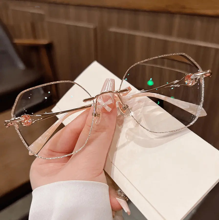 Add subtle sparkle to your look with our rose gold rimless geometric glasses! Featuring silver glitter cut-edge trim, elegant gemstone temple accents, and an oversized face-flattering shape. Perfect for Korean aesthetic & gentle luxury style. Shop today!