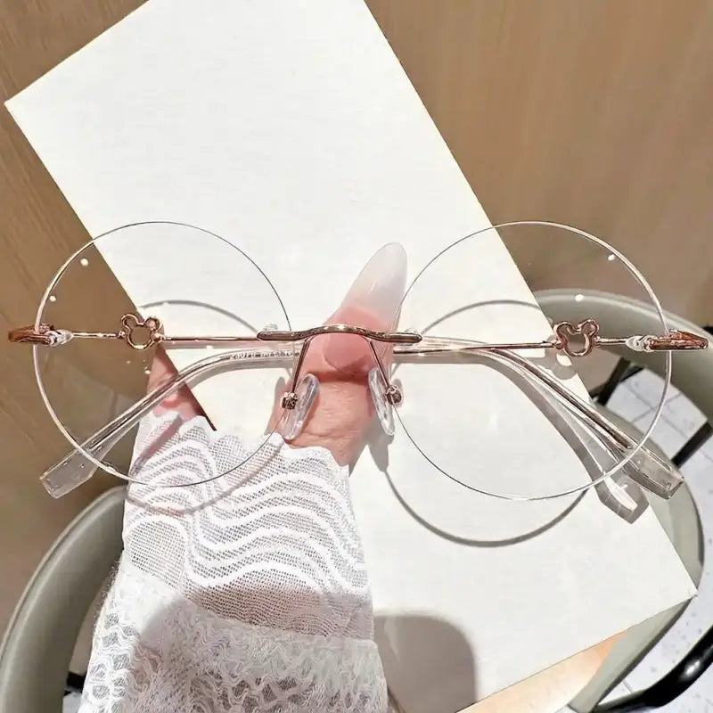 Add a playful touch to your look with our rose gold rimless round glasses! Featuring cute cartoon mouse head accents, lightweight frameless clear lenses, and elegant metal temples. Perfect for Korean aesthetic & theme park outfits. Shop today!